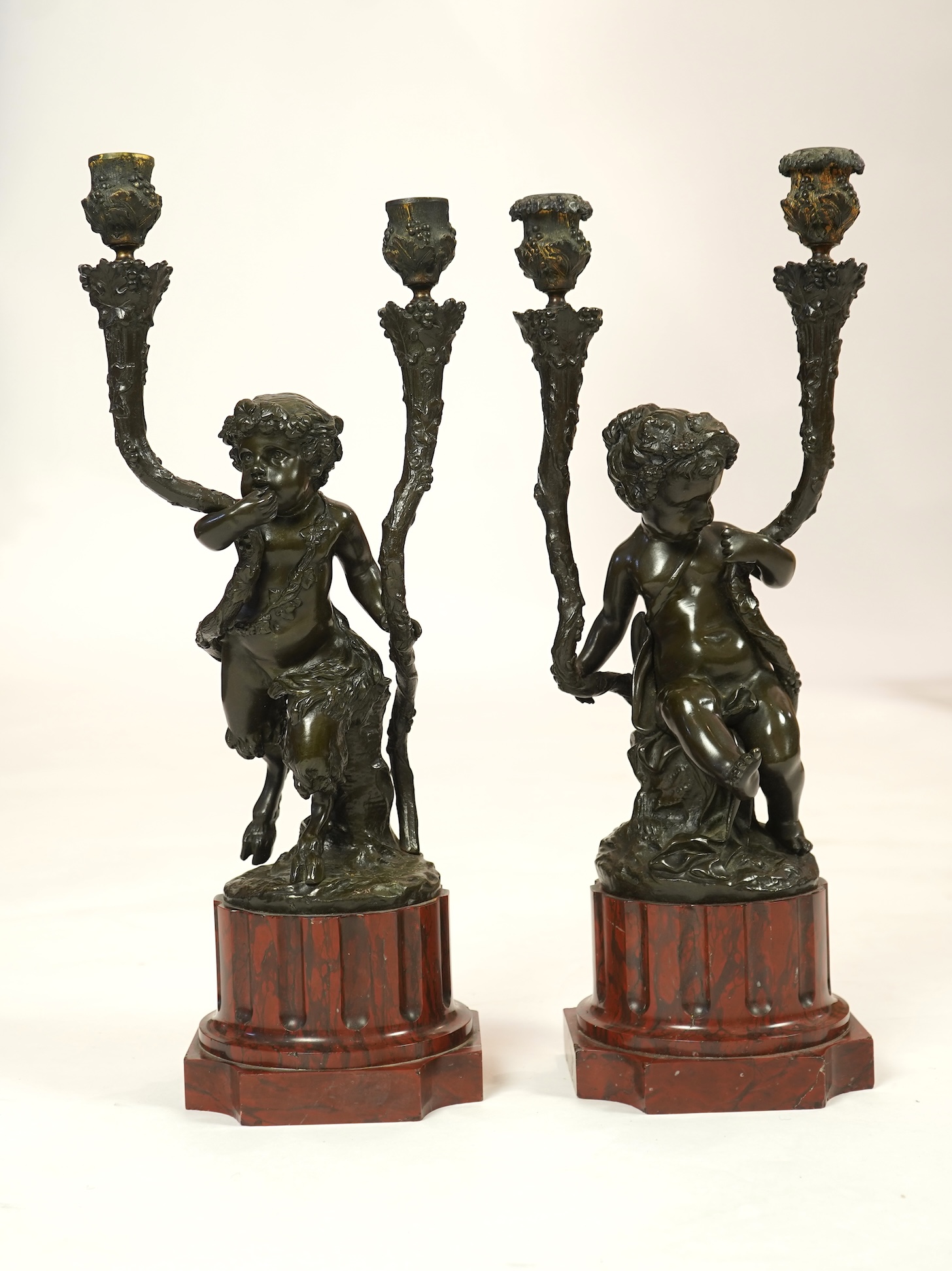 After Clodion. A pair of mid 19th century French bronze two branch figural candelabra